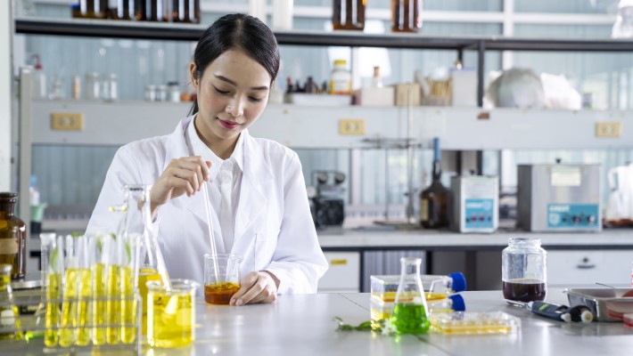 A lab specialist using a beaker and doing a test. 