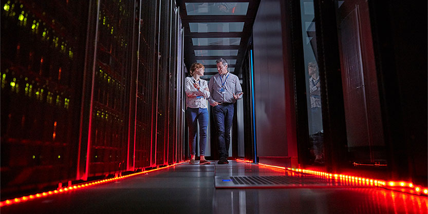 IT technicians talking and walking in dark server room