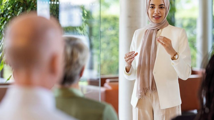 Young middle eastern businesswoman giving a speech in a business seminar.