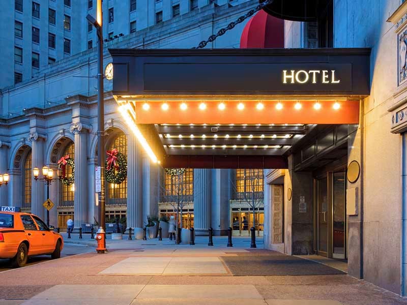 Photo of a hotel entrance and a waiting taxi cab in downtown Cleveland during the winter holidays.