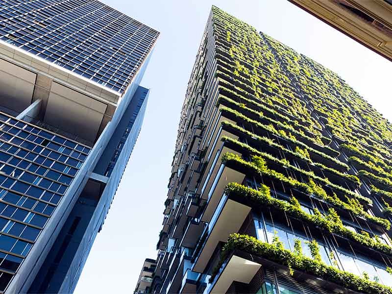 Low angle view of apartment building with vertical garden, sky background with copy space