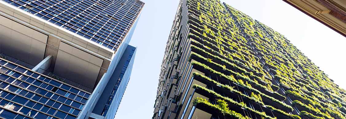 Low angle view of apartment building with vertical garden, sky background with copy space.