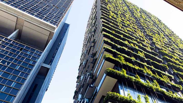 Low angle view of apartment building with vertical garden, sky background with copy space