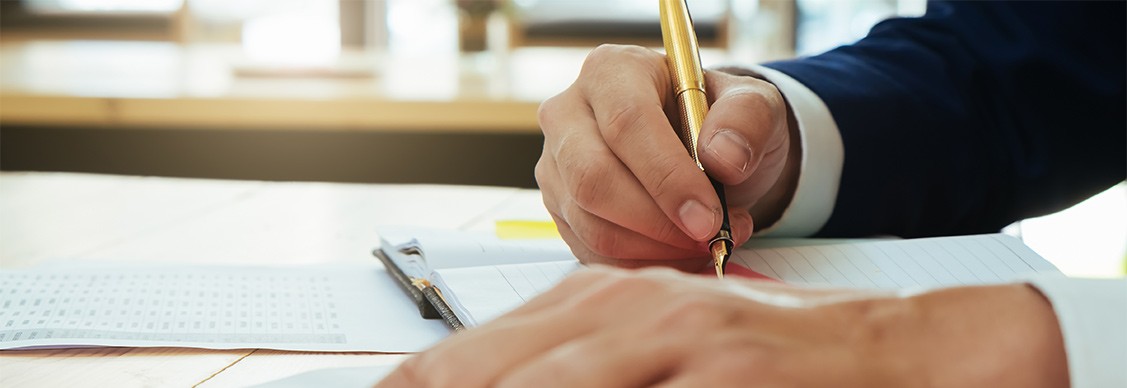 Man writing on paper with pen