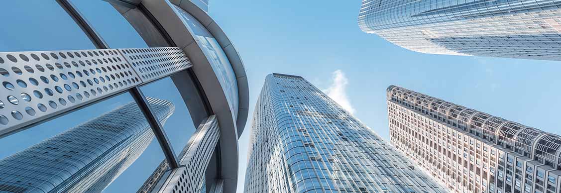 A panoramic view showcasing tall buildings against a clear sky in an urban cityscape.