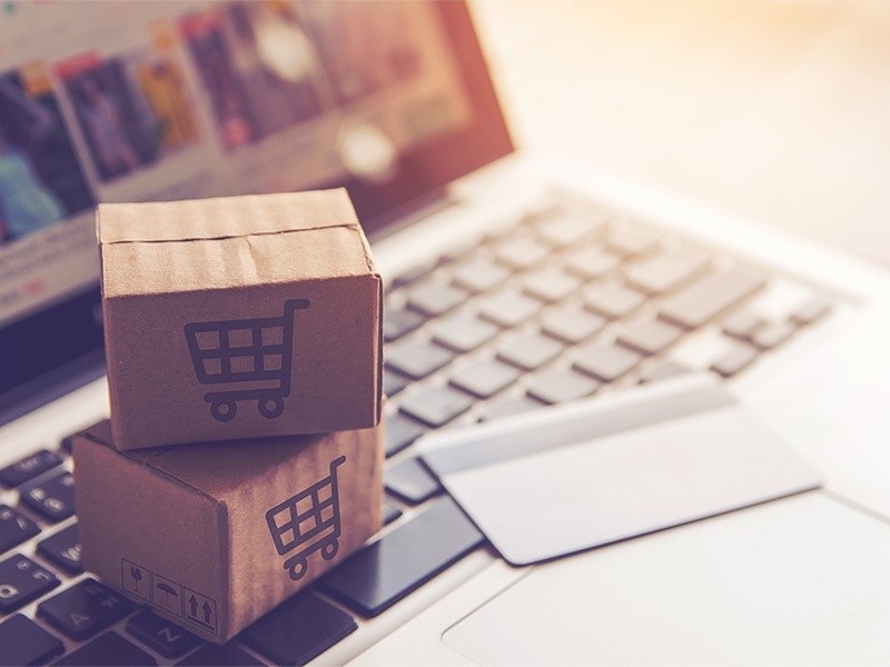 Graphic with a laptop and a paper box with a mark of shopping cart