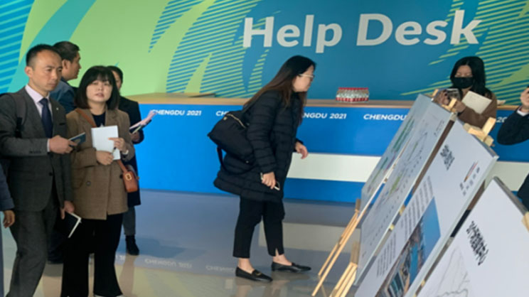 A women observing Chart Board while multiple professionals roaming in the venue