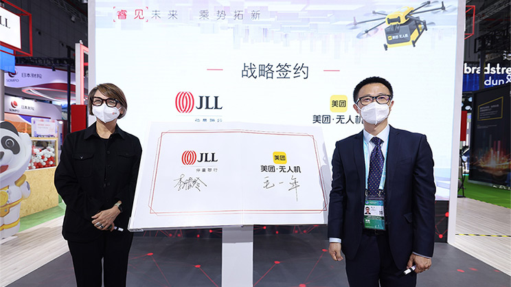 Two person are with the banner of JLL and Meituan UAV