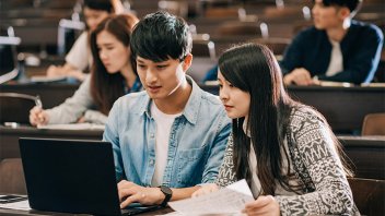 Students looking into a laptop
