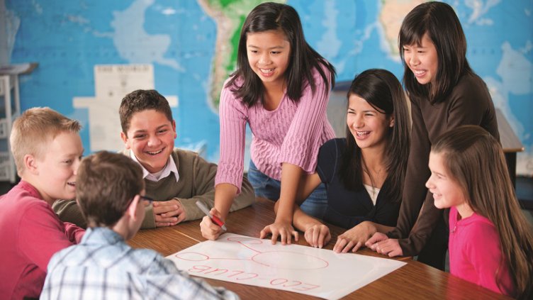 Eighth graders in a classroom working on a project. -