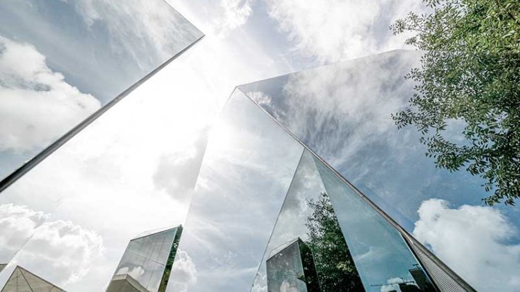 Glass building wit clouds at the background