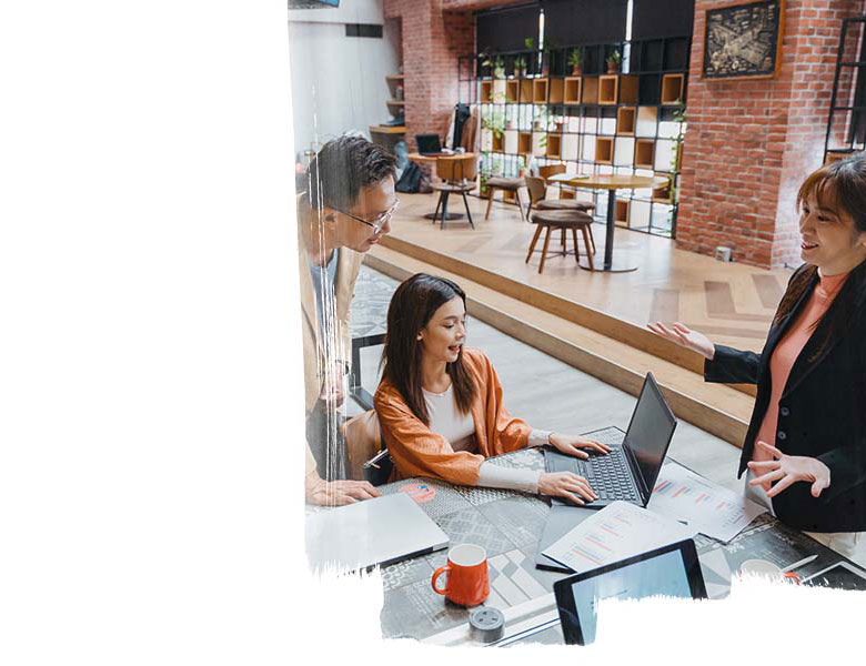 One man and three ladies in a collaborative office space, having a work group discussion 