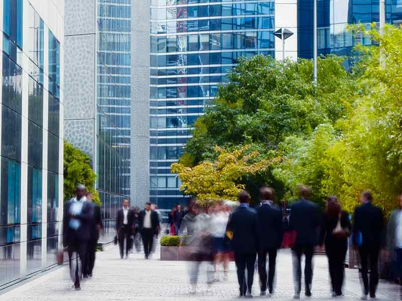 Numerous professional walking infront of buildings