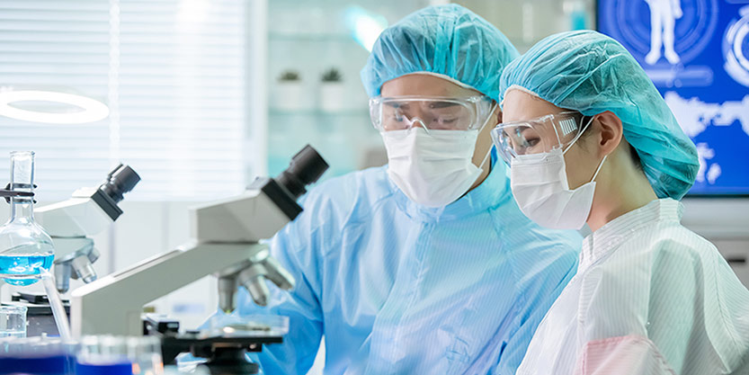 Asian scientist use microscope
