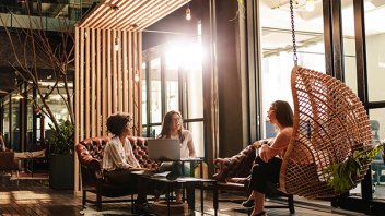 three women conversing in coworking lobby