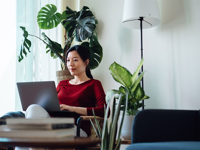 An asian Women sitting and working on a laptop	