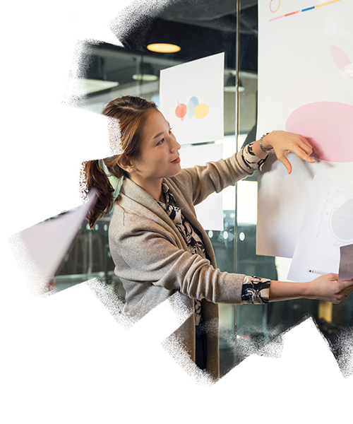 A woman working on a chart paper inside the office